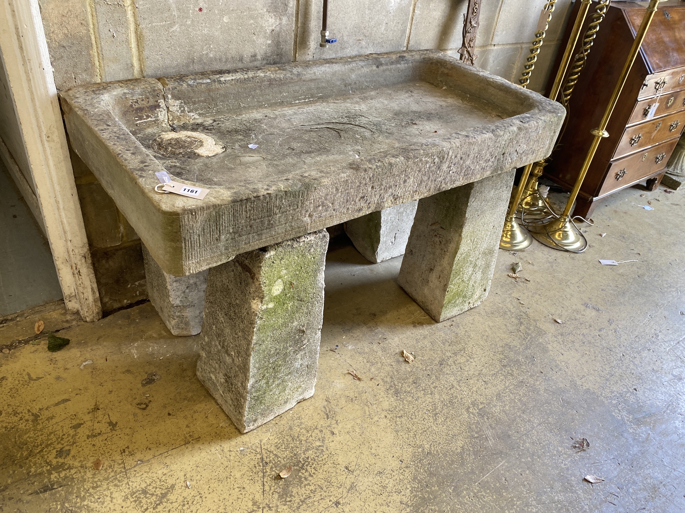A rectangular carved stone trough on four tapered stone pillars, width 120cm, depth 59cm, height 70cm